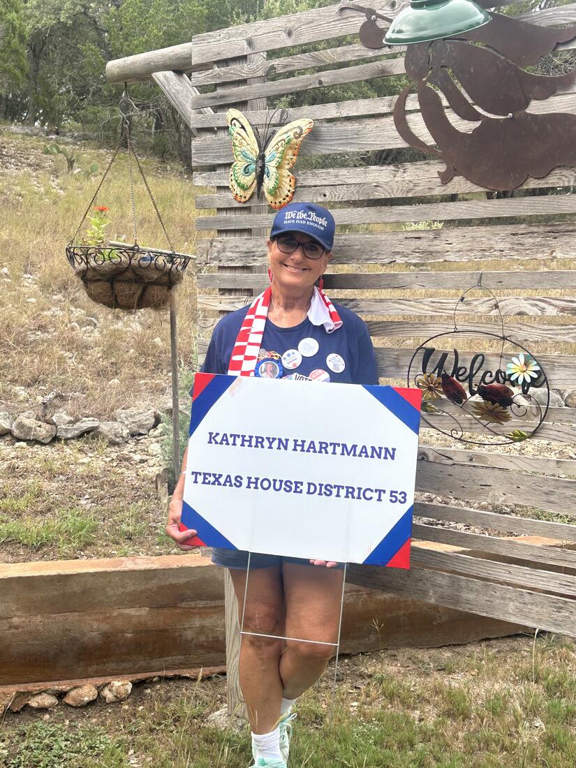 Kathryn with a campaign yard sign